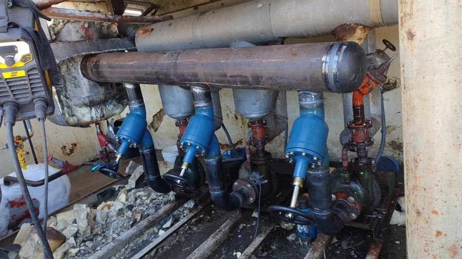 Coletor de amônia em aço carbono recém soldado, ligado a bombas com válvulas azuis, no túnel de congelamento